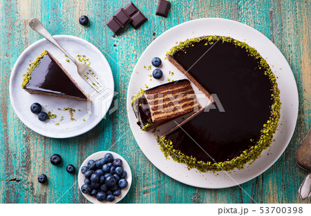 Chocolate cake on a white plate. Blue wooden background. Top view. 53700398