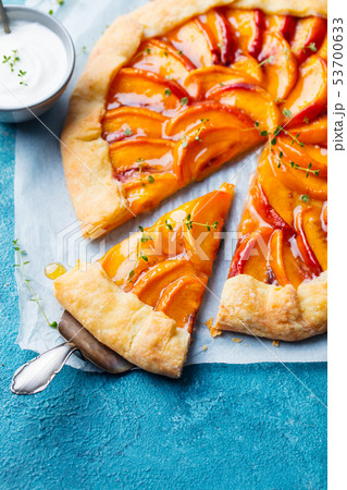 Peach galette, pie, cake with cream on blue background. Top view. Peach galette, pie, cake with cream on blue background. Top view. 53700633