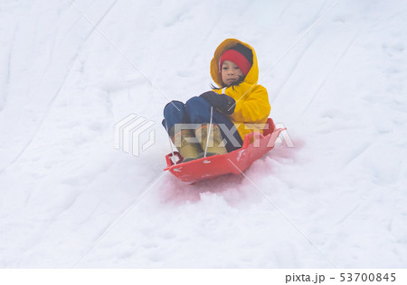 Little Japanese girl is sliding down the snow sled 53700845