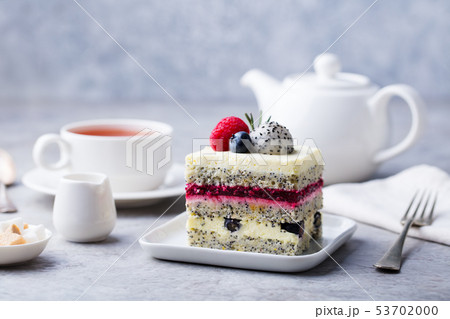 Berry, poppy seed layered cake on white plate. Breakfast concept. Grey background. Copy space. Berry, poppy seed layered cake on white plate. Breakfast concept. Grey background. Copy space. 53702000