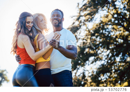 Three friends having fun dancing kizomba on a meadow 53702776