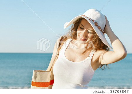 Smiling young woman in hat on beach Smiling young woman in hat on beach 53703847