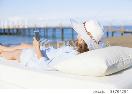 Woman using smartphone on the beach 53704294