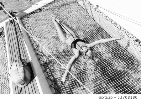 Womanin bikini tanning and relaxing on a summer sailin cruise, lying in hammock of luxury catamaran 53708180