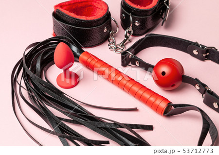 Set of erotic toys for BDSM. The game of sexual slavery with handcuffs, whip, gag and leather straps Set of erotic toys for BDSM. The game of sexual slavery with handcuffs, whip, gag and leather straps 53712773