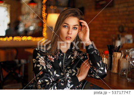 Pretty woman in a black jacket with flowers Pretty woman in a black jacket with flowers 53717747