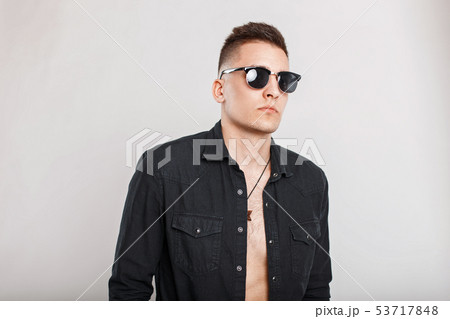 Handsome man in a black shirt with sunglasses Handsome man in a black shirt with sunglasses 53717848
