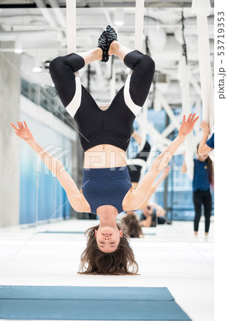 Woman hanging upside down in a hammock. Fly yoga class. Woman hanging upside down in a hammock. Fly yoga class. 53719353