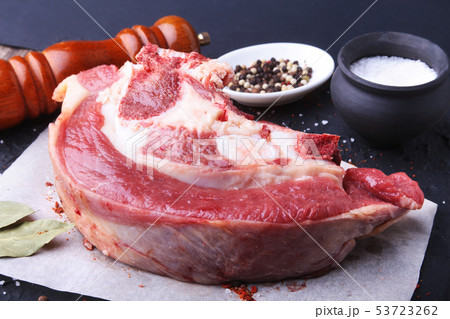 Raw fresh meat, uncooked lamb or beef ribs with pepper, garlic, salt, bay leaves and spices on dark 53723262