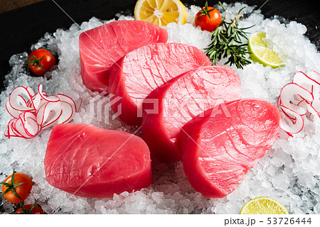 slice of tuna fish with lime, rosemary and cherry tomatoes on the ice slice of tuna fish with lime, rosemary and cherry tomatoes on the ice 53726444