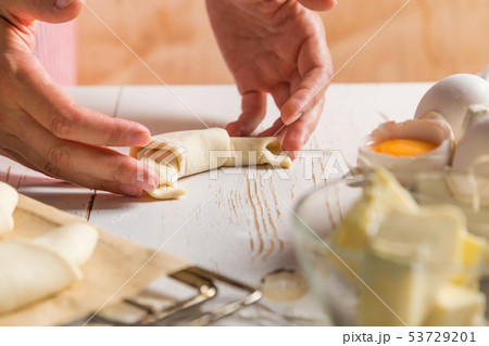 Baker making croissants on rustic wood background 53729201