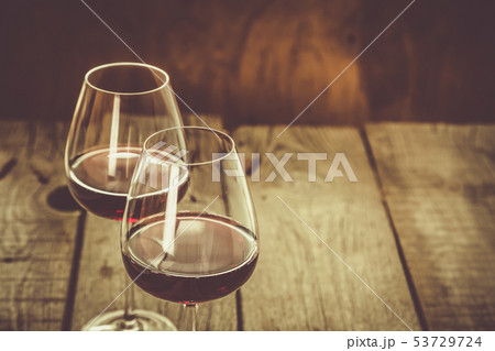 Glasses with red wine on rustic wood background Glasses with red wine on rustic wood background 53729724