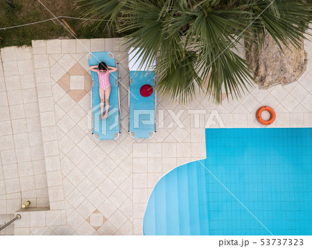 Little girl sunbathing by a swimming pool 53737323