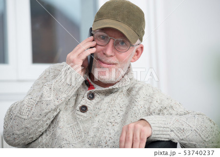 mature man with  baseball cap using a smartphone 53740237