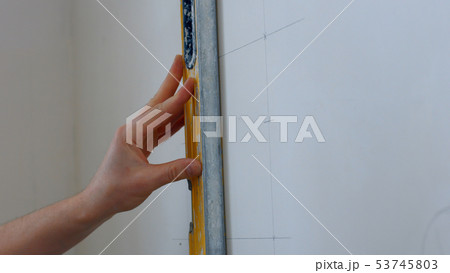 Builder draws marking on the wall. 53745803