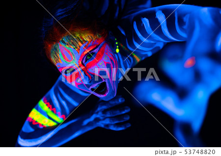 Close-up Portrait of Wild and frantic Young naked bodyarted woman in blue glowing ultraviolet paint Close-up Portrait of Wild and frantic Young naked bodyarted woman in blue glowing ultraviolet paint 53748820