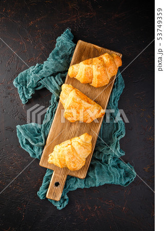 Freshly baked croissants on wooden cutting board, Freshly baked croissants on wooden cutting board, 53749359