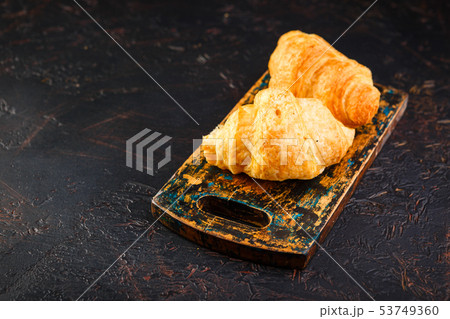 Freshly baked croissants on wooden cutting board, 53749360