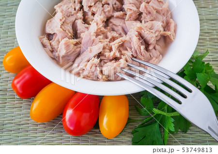 Tuna in white bowl, fork and cherry tomatoes 53749813