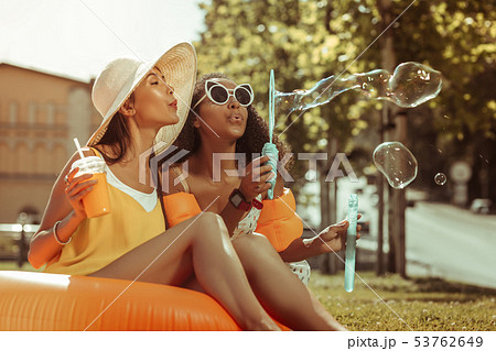 Profile portrait of arresting young blowing the bubbles off outdoors. 53762649