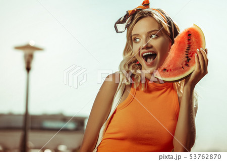 Face portrait of young lady posing with a watermelon piece Face portrait of young lady posing with a watermelon piece 53762870