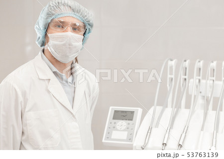 The work of a doctor. Young man dentist in dental clinic. Medicine, health, stomatology concept The work of a doctor. Young man dentist in dental clinic. Medicine, health, stomatology concept 53763139