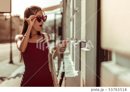 Dark-haired slim hot woman feeling shocked while walking the streets 53763518