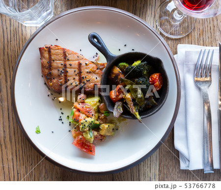 Top view of grilled tuna steak served with avocado and tomatoes 53766778