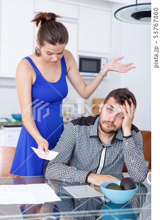 Unhappy young woman and man with financial bills having conflict Unhappy young woman and man with financial bills having conflict 53767860