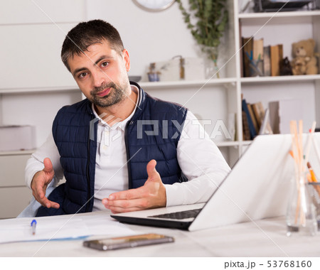 Young man with laptop and papers working in office 53768160