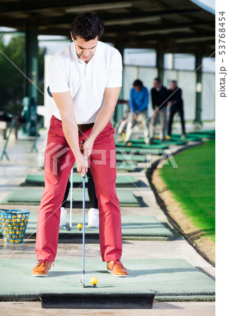 Man playing golf is going to hit ball at golf course Man playing golf is going to hit ball at golf course 53768454