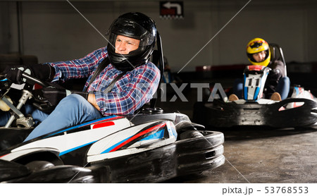 Man and his friends competing on racing cars Man and his friends competing on racing cars 53768553