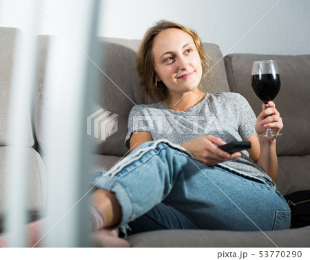 Woman relaxing at home watching TV 53770290