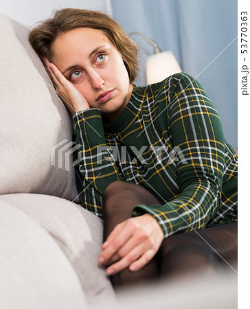 Portrait of sorrowful woman sitting at home 53770363