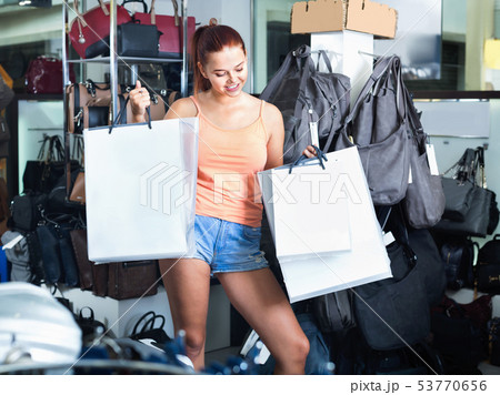 Teenager girl shopping in store with bags 53770656
