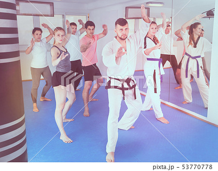 Young adult trainees practicing in karate class 53770778