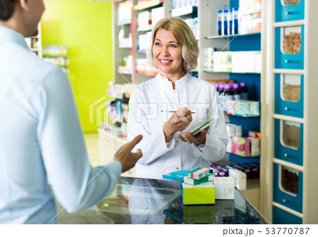 Female pharmacist counseling customer about drugs usage Female pharmacist counseling customer about drugs usage 53770787