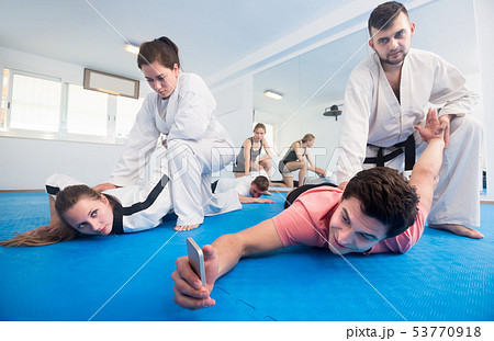 trainees making selfies while sparring in pairs in taekwondo class 53770918