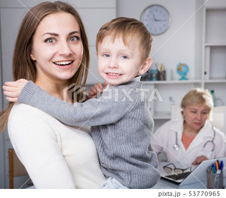 Woman is satisfied of medical examinaing of her son 53770965