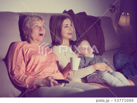 Woman with her mother and son are watching film in time evening rest 53771089