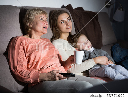 Woman with her mother and son are watching film in time evening rest 53771092