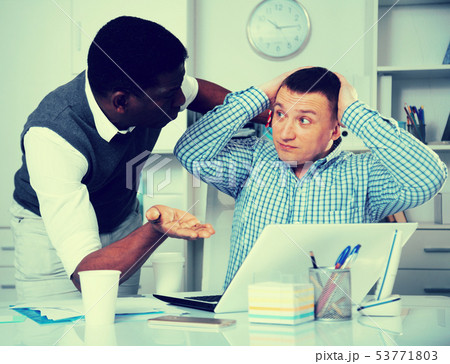 Two men in office working at laptop and documents Two men in office working at laptop and documents 53771803