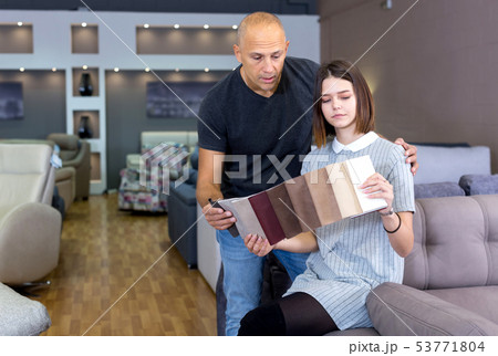 Husband and wife in process of choosing upholstery fabric 53771804