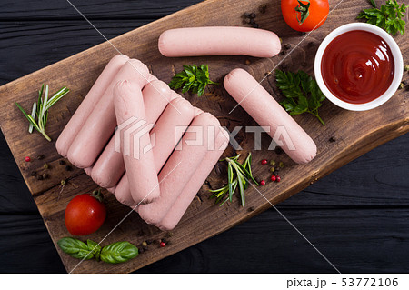 Raw beef sausages with pepper , herbs and ketchup 53772106