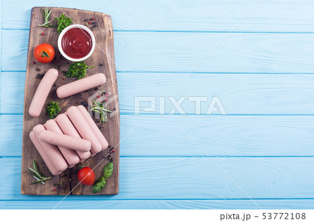 Raw beef sausages with pepper , herbs and ketchup 53772108