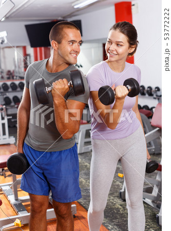 Man and woman posing with dumbbells Man and woman posing with dumbbells 53772222