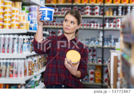 Woman is choosing with paint for repair 53772867
