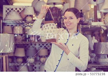 Woman demonstraiting lamp in store Woman demonstraiting lamp in store 53773236