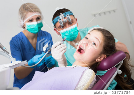Frightened girl during dental treatment Frightened girl during dental treatment 53773784