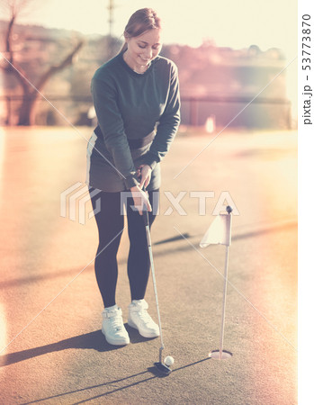 Female golf player getting ready to hit ball Female golf player getting ready to hit ball 53773870